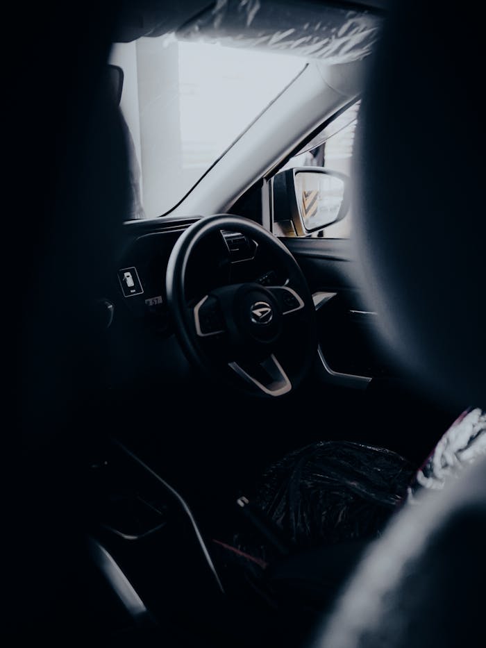 A sleek interior of a modern car showcasing the steering wheel and dashboard in a unique perspective.